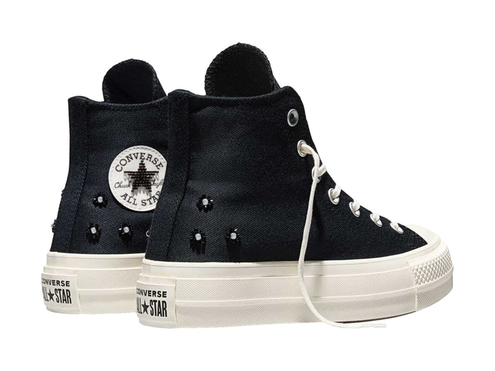 Tenis Converse negros de bota alta con suela de plataforma blanca y agujetas blancas.
