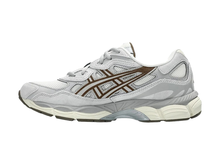 Tenis ASICS GEL-NYC color gris cemento y crema con detalles marrones, vista lateral.