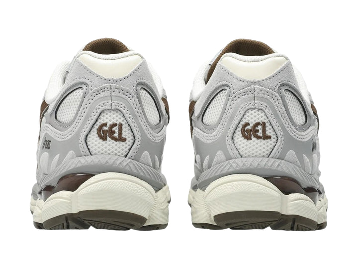 Tenis ASICS GEL-NYC color gris cemento y crema con detalles marrones y suela amortiguada.