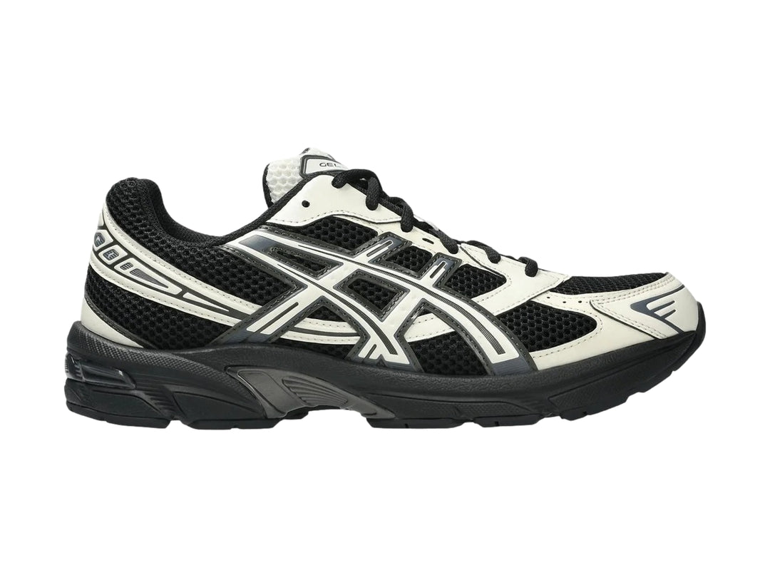 Tenis deportivos ASICS GEL-1130 en colores negro y crema con detalles en malla y suela negra.
