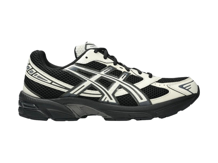 Tenis deportivos ASICS GEL-1130 en color negro y crema con suela negra y detalles en malla.