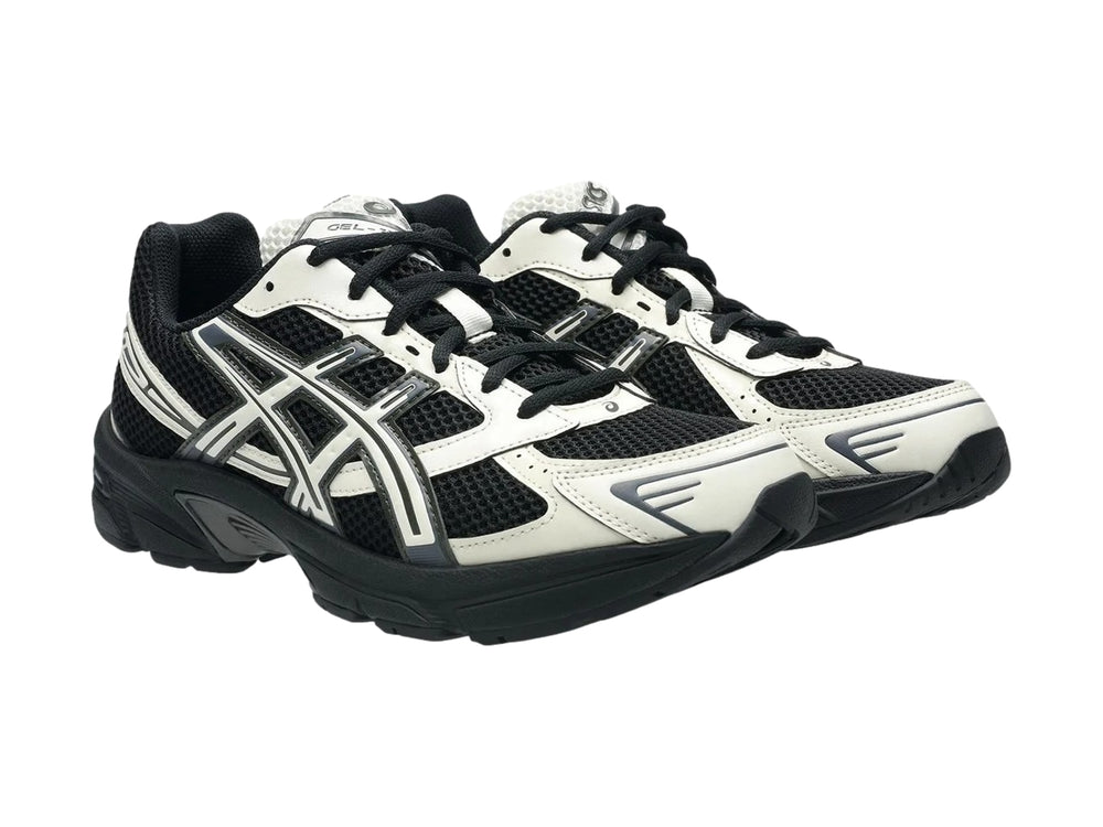 Tenis deportivos ASICS GEL-1130 en color negro y crema con suela negra y detalles en malla.