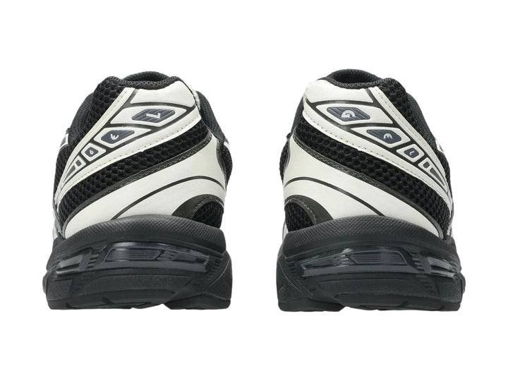 Tenis deportivos ASICS GEL-1130 en color negro y crema con suela negra y detalles en malla.