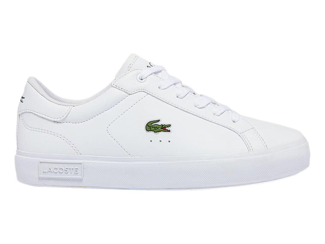 Tenis deportivos Lacoste color blanco para niño con logotipo del cocodrilo en el lateral y suela blanca.