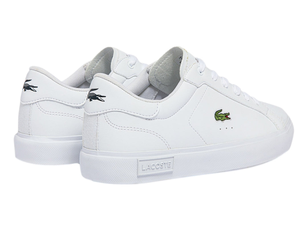 Tenis deportivos Lacoste color blanco para niño con logotipo del cocodrilo en el lateral y suela blanca.