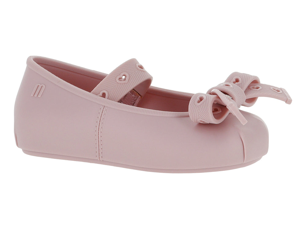 Zapato plano color rosa para niña con detalle de moño y corazones en la parte superior.