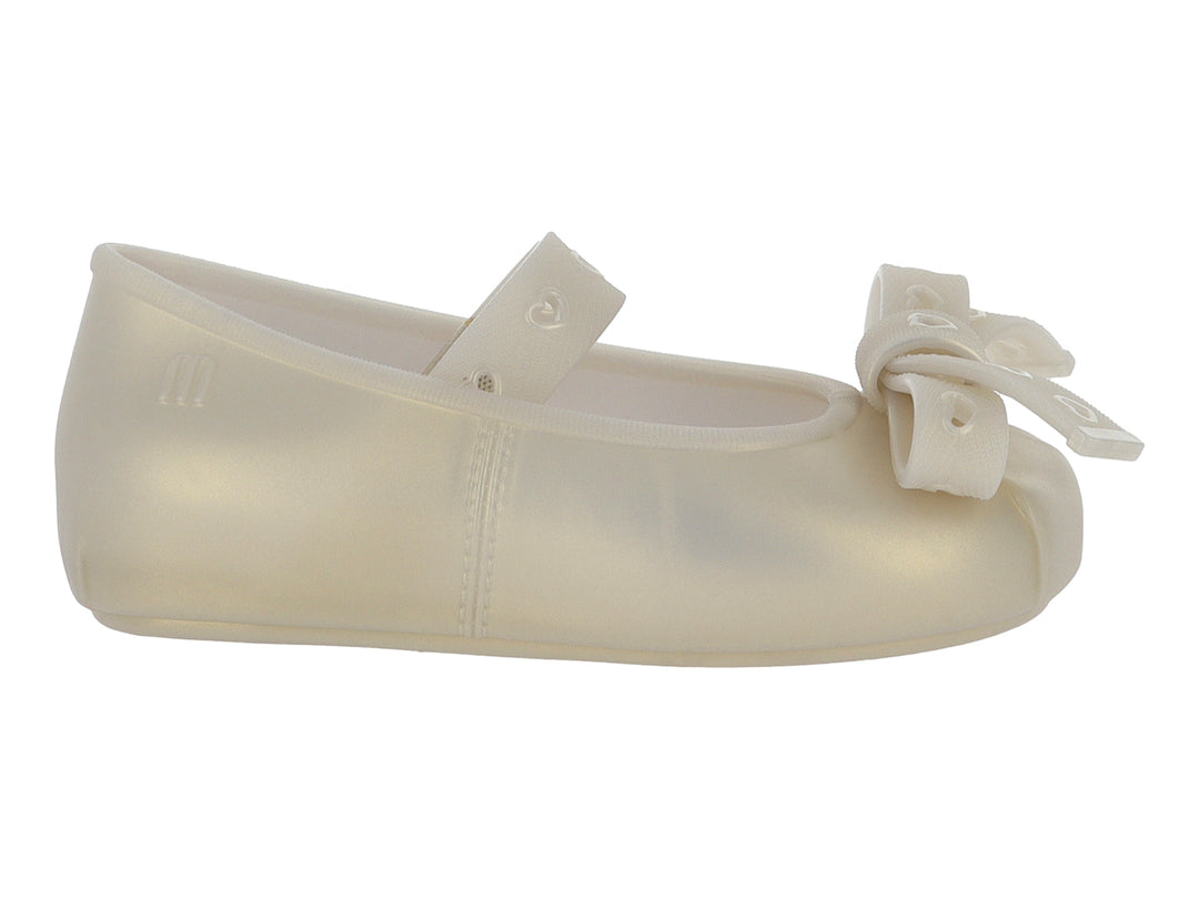 Zapato plano color beige para niña con detalle de moño al frente.