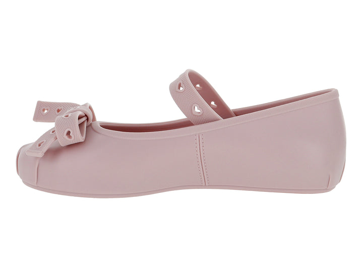Zapato plano color rosa para niña con correa y moño decorado con detalles de corazones.