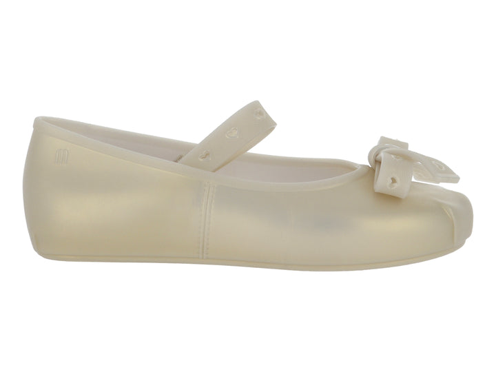 Zapato plano color beige para niña con moño frontal y correa con detalles de corazones.