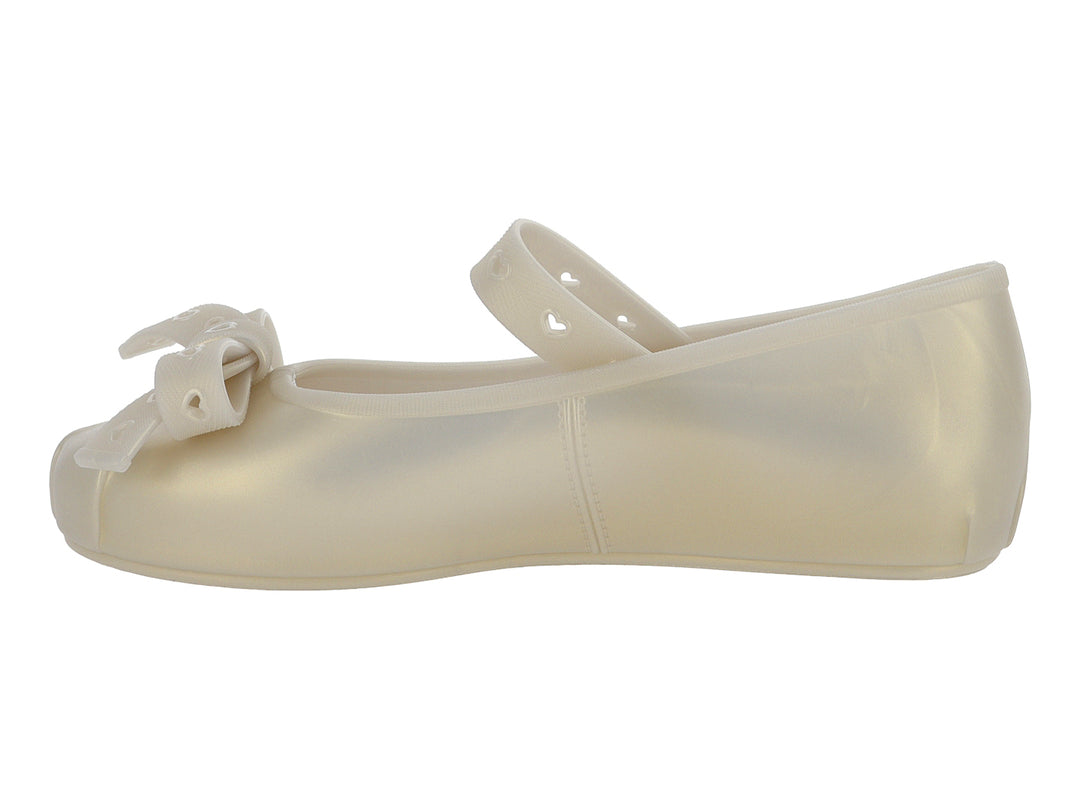 Zapato plano color beige para niña con moño frontal y correa con detalles de corazones.