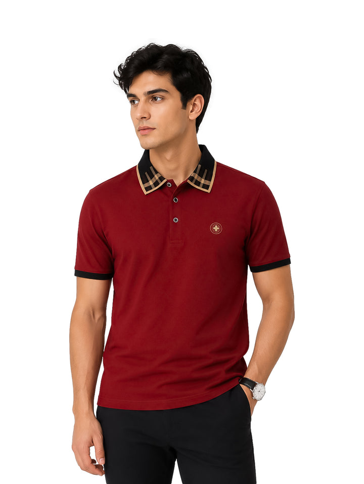 Hombre vistiendo playera polo color burgundy con detalles negros y dorados en el cuello.