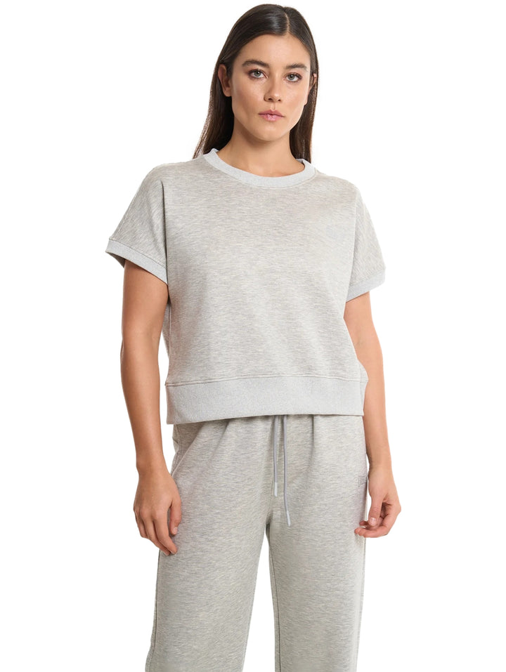 Mujer vistiendo una playera de manga corta en color gris jaspe.