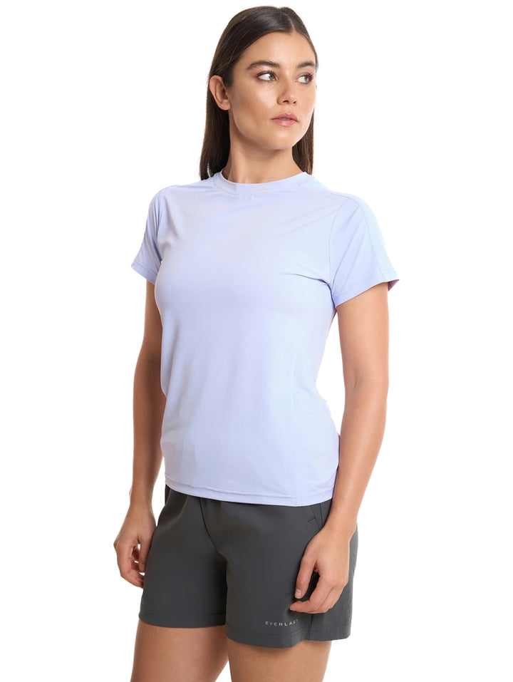 Mujer vistiendo playera deportiva color lila de manga corta y cuello redondo marca Everlast.