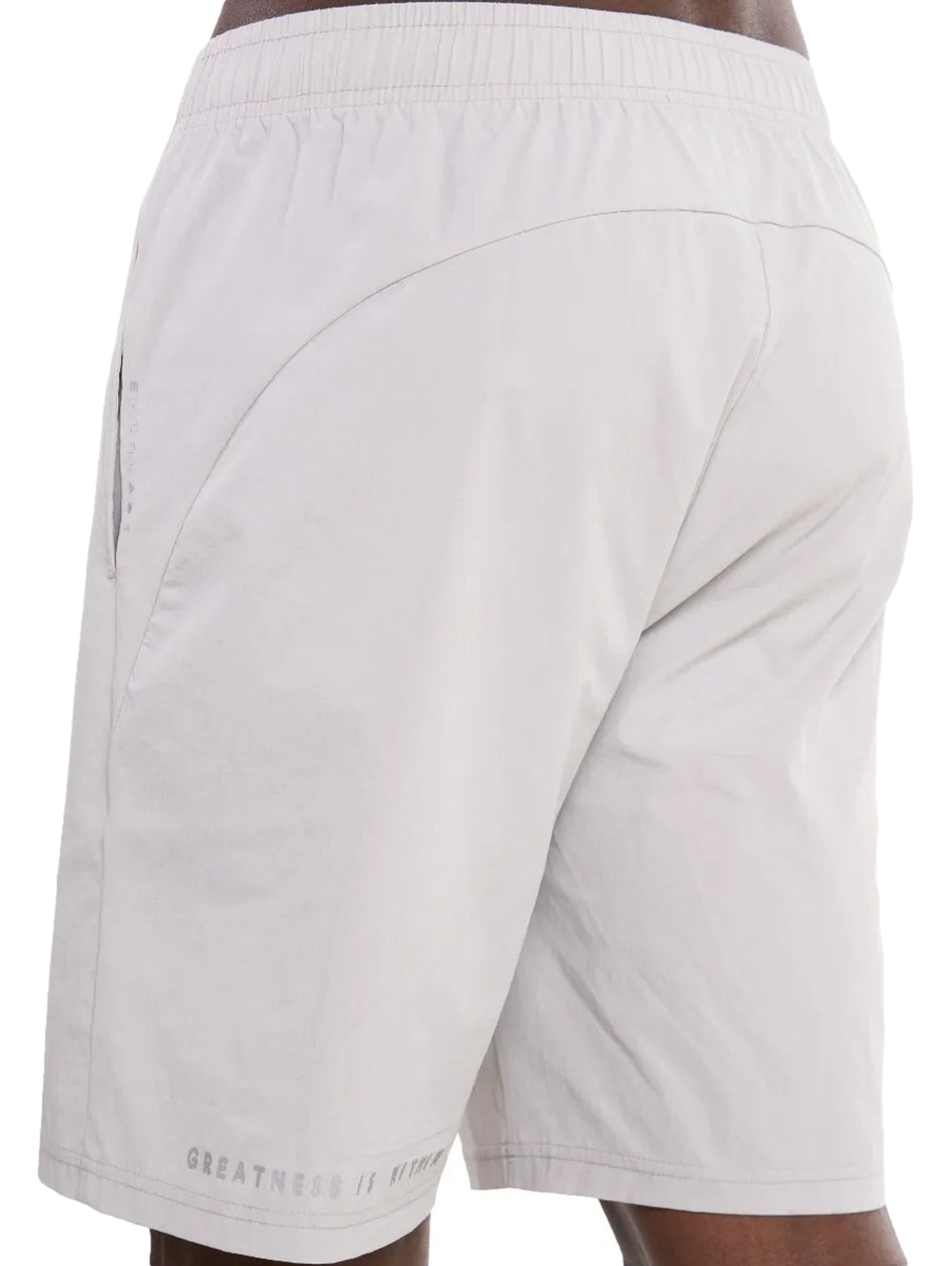 Hombre vistiendo shorts deportivos de color gris claro con tenis blancos.