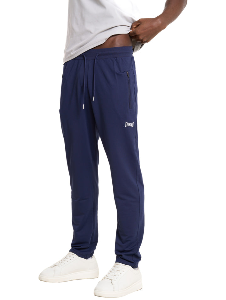 Hombre vistiendo pantalón deportivo Everlast color azul marino con logotipo blanco.