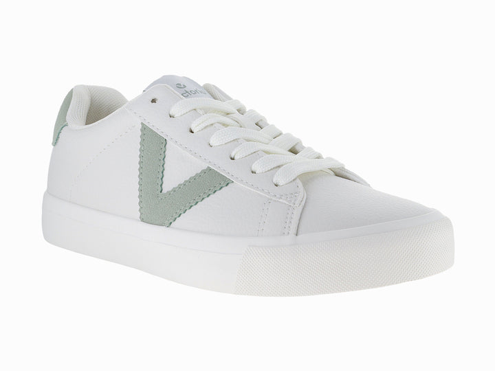 Tenis blancos de tela con detalles en color verde claro y suela blanca.