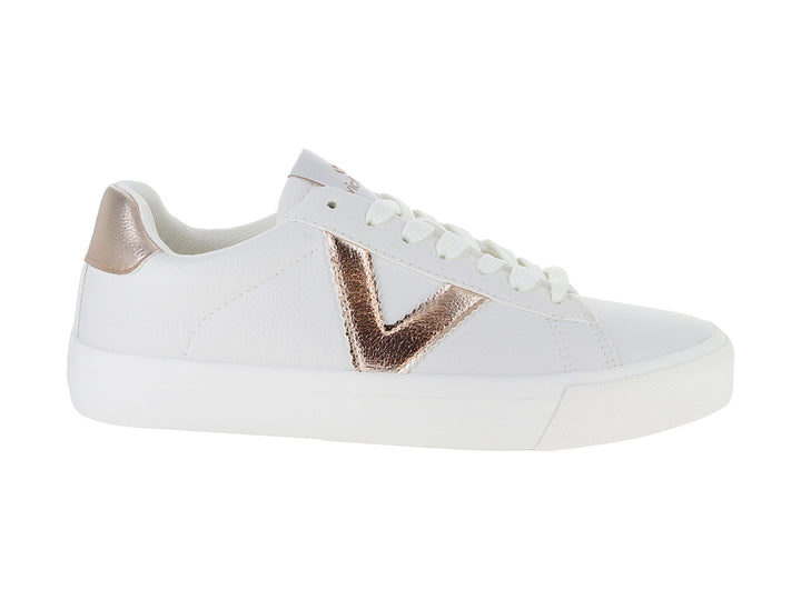 Tenis blancos Victoria con detalles metálicos en oro rosa y cordones blancos.