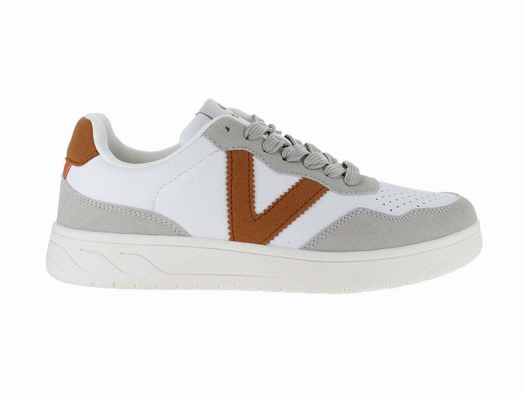 Tenis Victoria blancos con detalles en gris y marrón, suela blanca y cordones grises.