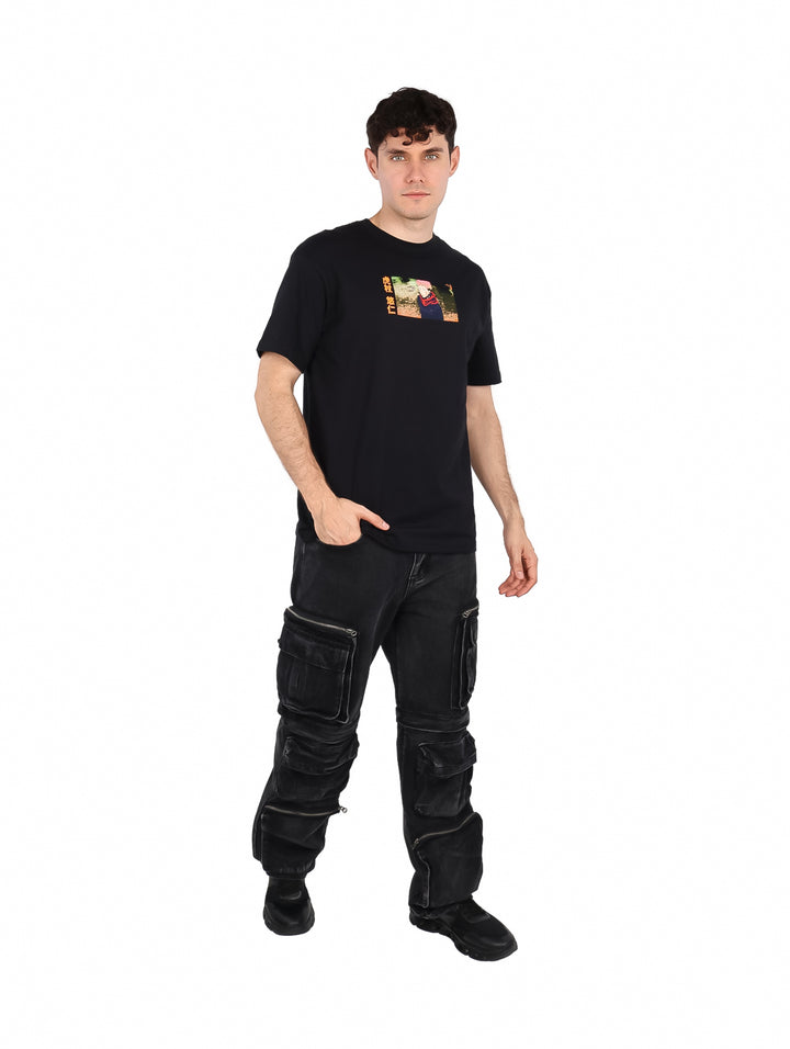 Hombre vistiendo playera negra oversized con estampado gráfico frontal.
