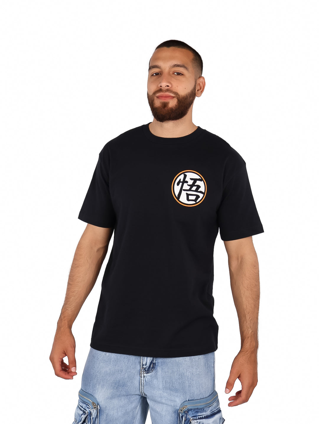 Hombre vistiendo playera negra oversized con estampado circular de Dragon Ball en el pecho.