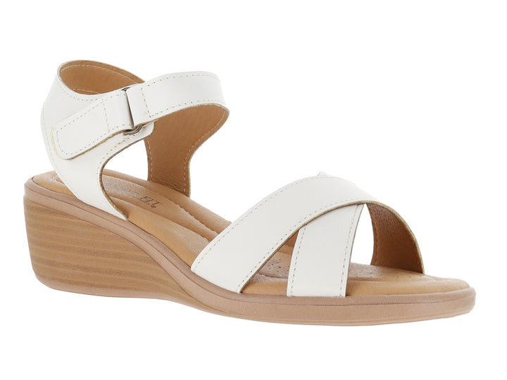 Sandalia blanca de cuña con suela beige y correa ajustable en el tobillo.