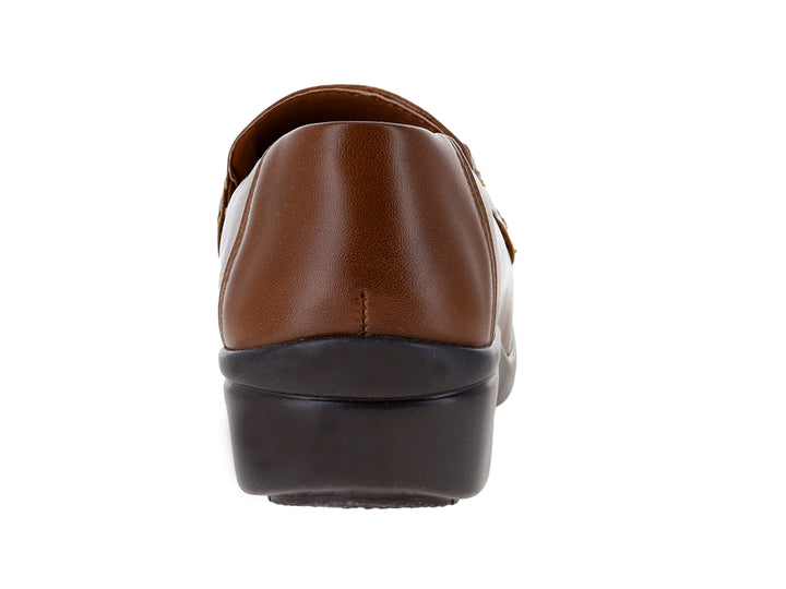 Zapato plano color camel con suela negra y detalle de hebilla dorada en la parte superior.