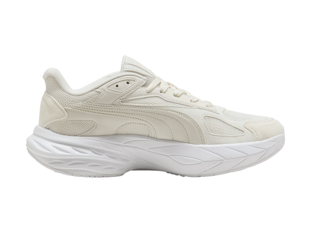 Tenis PUMA en color gris claro y blanco con suela gruesa y diseño moderno.