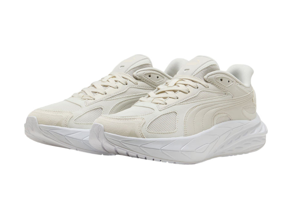 Tenis PUMA en color gris claro y blanco con suela gruesa y diseño moderno.