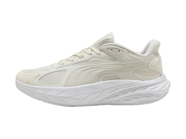 Tenis PUMA en color gris claro y blanco con suela gruesa y diseño moderno.