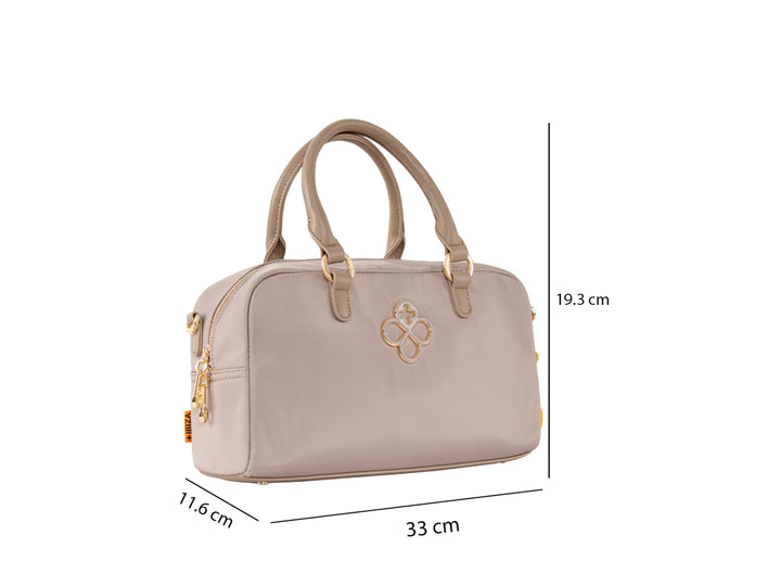 Bolsa de mano color taupe con asa superior, detalles dorados y un accesorio colgante color naranja.