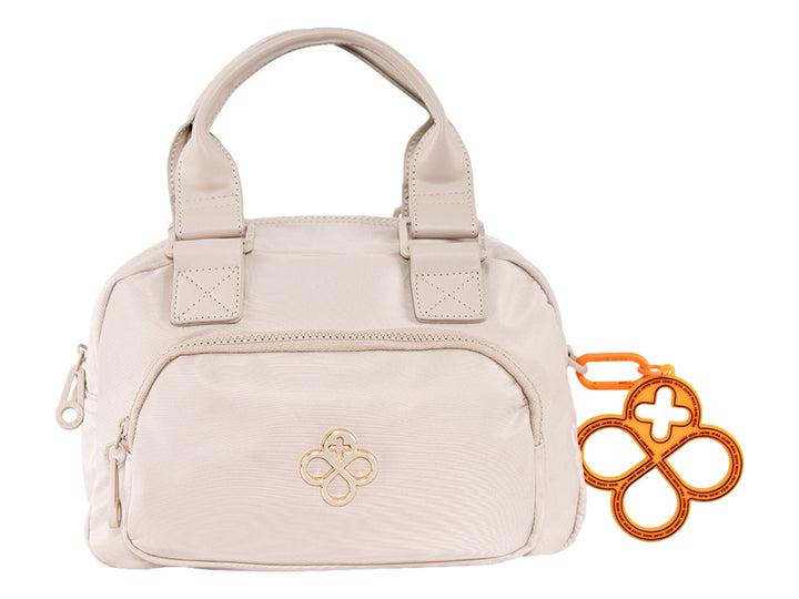 Bolsa de mano color beige de Jaime Ibiza con asa superior y un accesorio decorativo naranja.