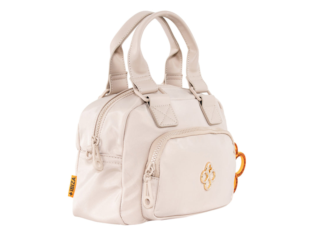 Bolsa de mano color beige de Jaime Ibiza con asa superior y un accesorio decorativo naranja.
