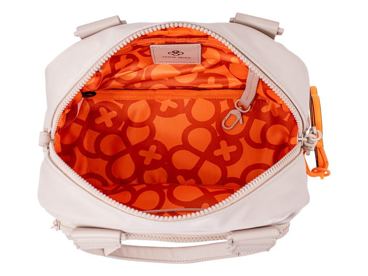 Bolsa de mano color beige de Jaime Ibiza con asa superior y un accesorio decorativo naranja.