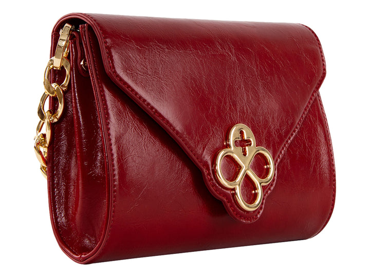 Bolsa roja de cuero con herraje dorado central y correa ajustable.