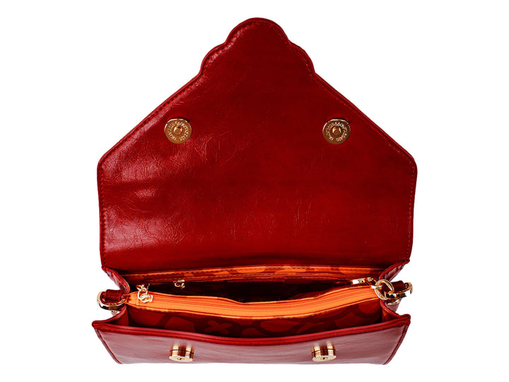 Bolsa roja de cuero con herraje dorado central y correa ajustable.