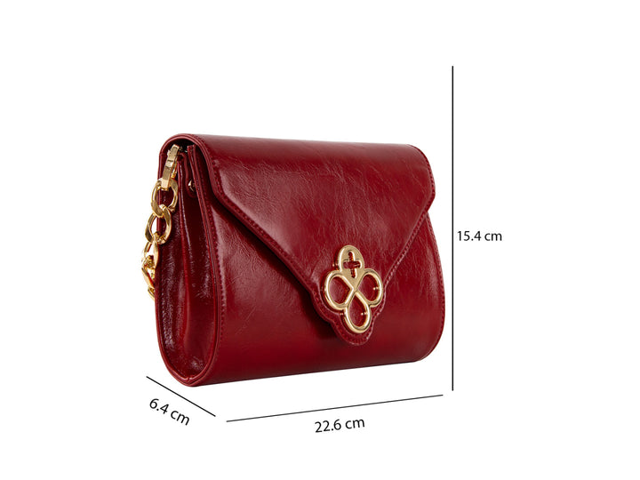 Bolsa roja de cuero con herraje dorado central y correa ajustable.