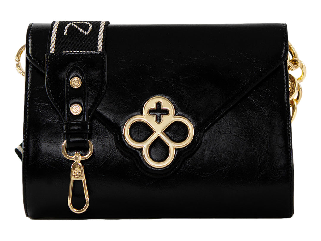 Bolso Jaime Ibiza color negro con detalles dorados, correa textil y cierre de solapa.