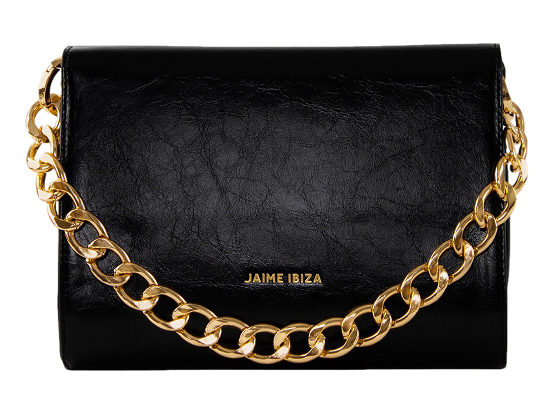 Bolso Jaime Ibiza color negro con detalles dorados, correa textil y cierre de solapa.