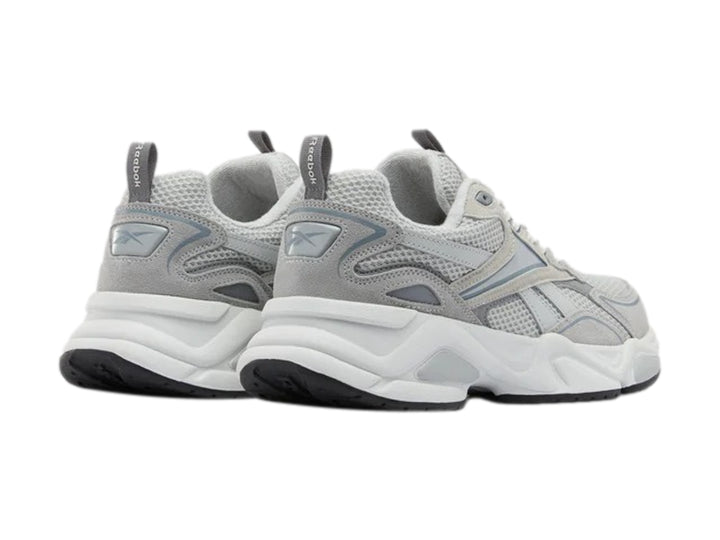 Tenis deportivos Reebok color gris y blanco con suela gruesa y detalles de malla.