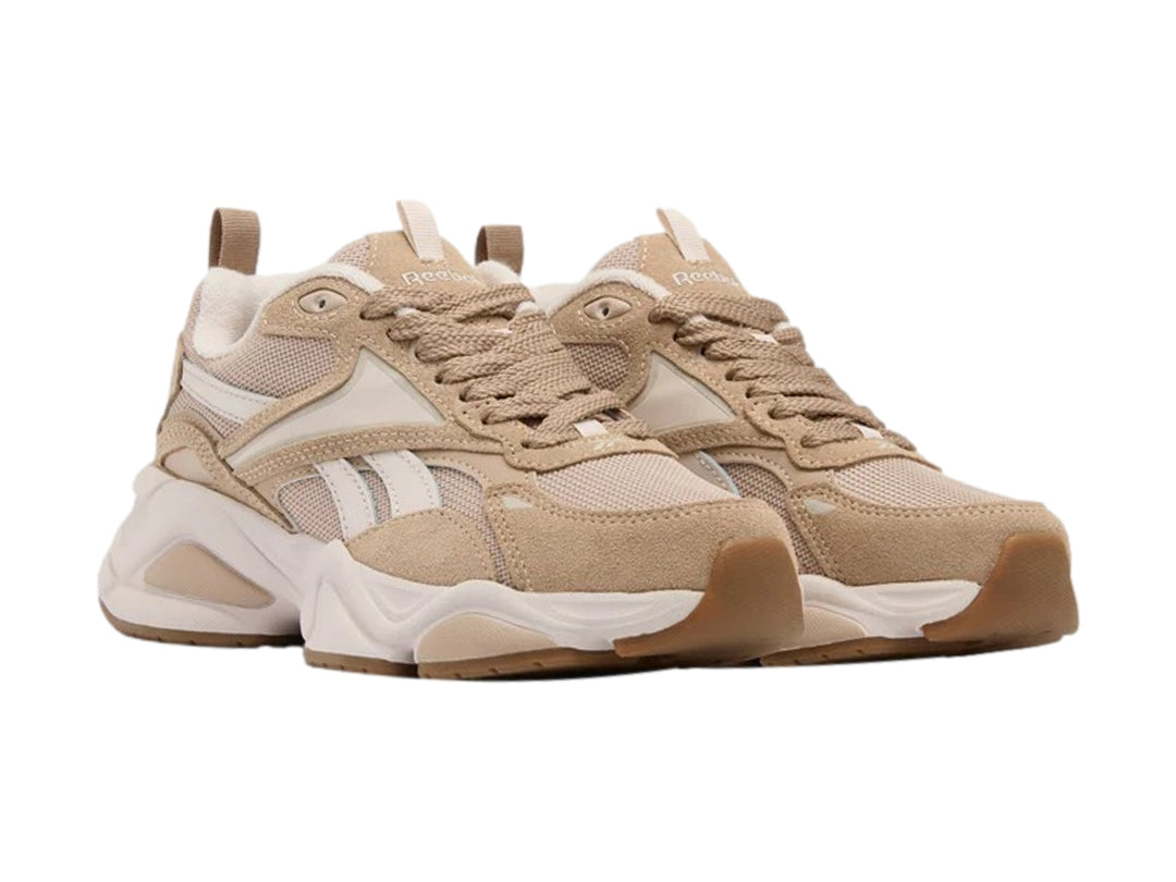 Tenis deportivos Reebok en color beige y blanco con suela chunky blanca y detalles en marrón.