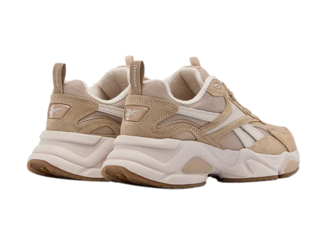 Tenis deportivos Reebok en color beige y blanco con suela chunky blanca y detalles en marrón.