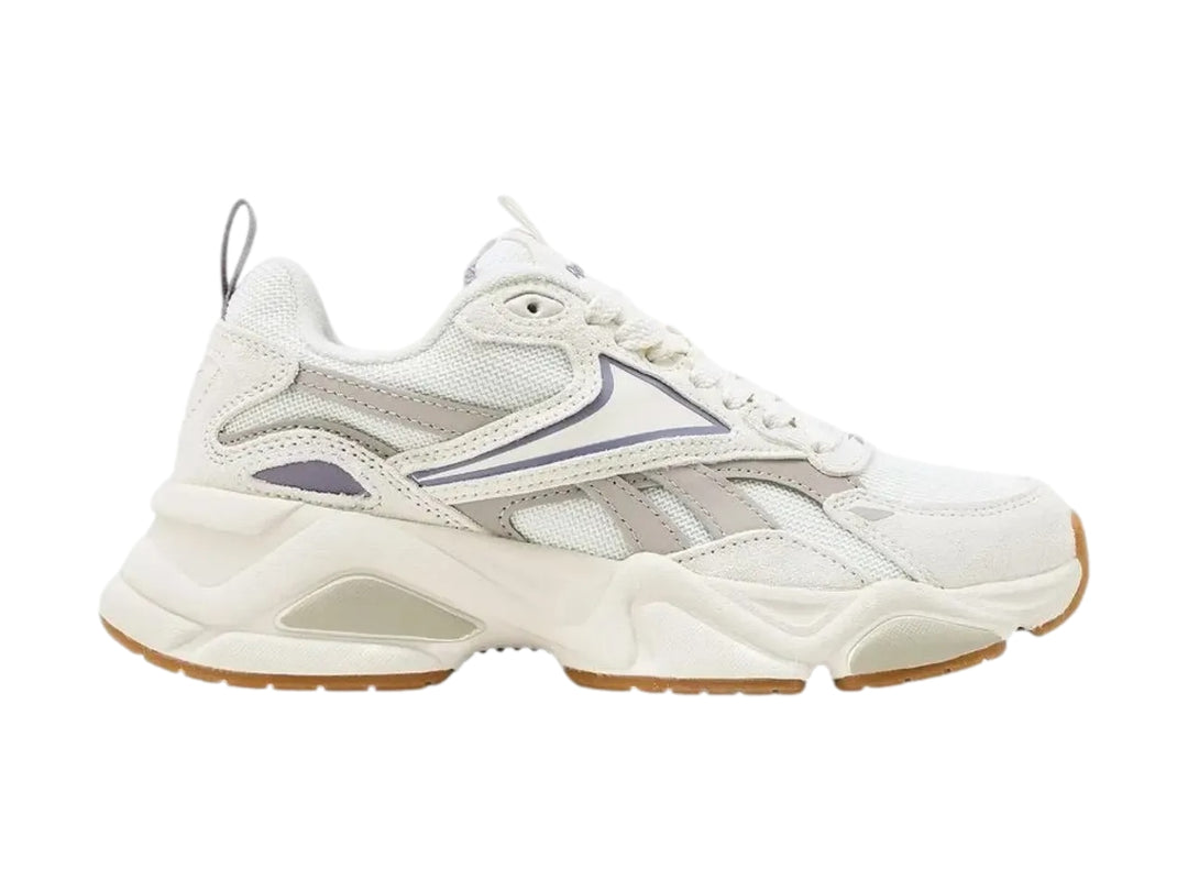 Tenis Reebok blancos con detalles en morado claro y suela de goma color café.