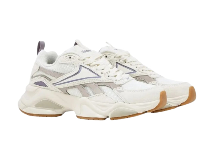 Tenis Reebok blancos con detalles en morado claro y suela de goma color café.