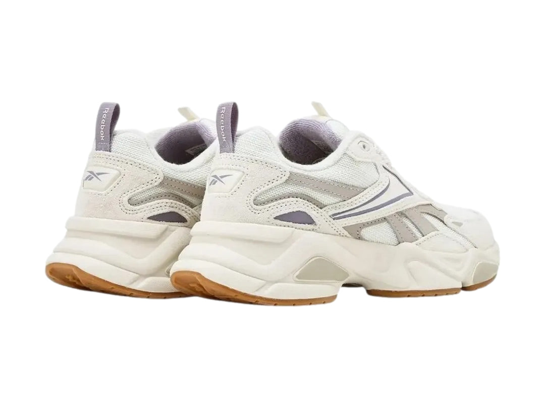 Tenis Reebok blancos con detalles en morado claro y suela de goma color café.