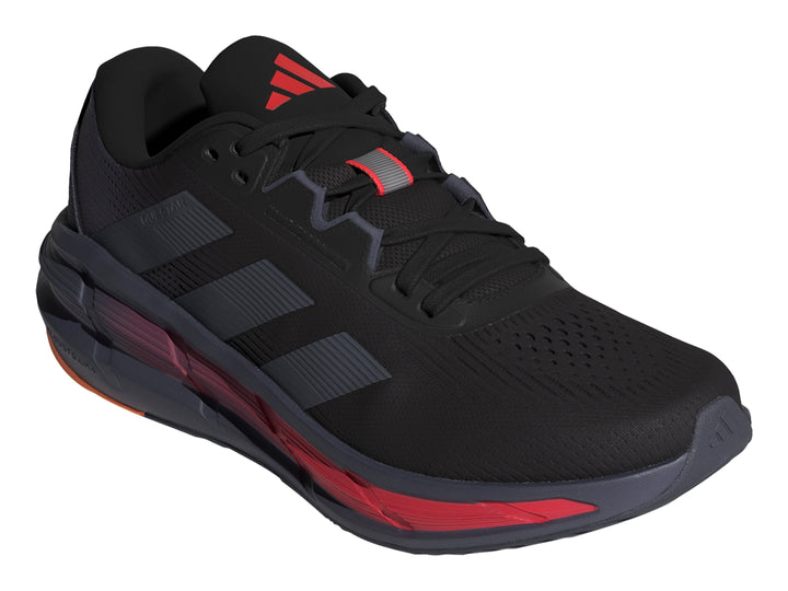 Tenis deportivos Adidas Questar 3 en color negro con detalles en rojo y naranja en la suela.