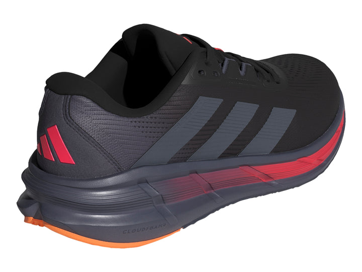 Tenis deportivos Adidas Questar 3 en color negro con detalles en rojo y naranja en la suela.