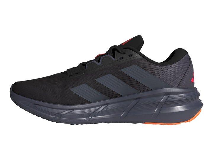 Tenis deportivos Adidas Questar 3 en color negro con detalles en rojo y naranja en la suela.