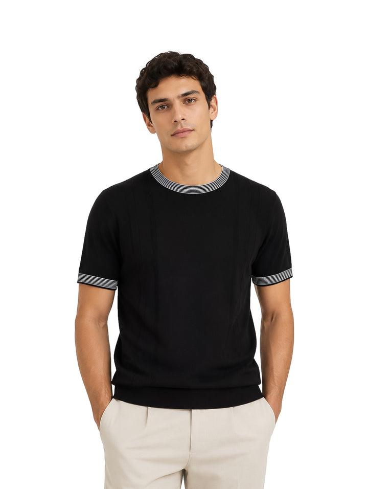 Hombre vistiendo playera tejida color negro con detalles de rayas blancas en cuello y mangas.