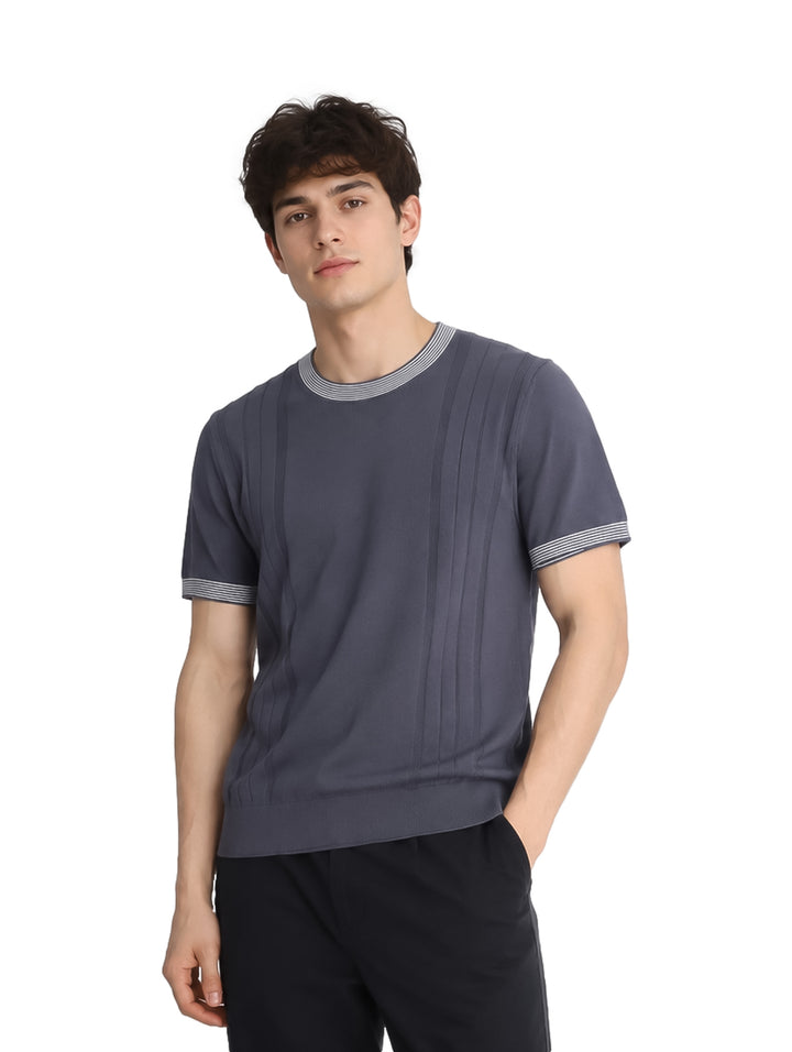 Hombre vistiendo playera tejida color gris con detalles blancos en cuello y mangas.