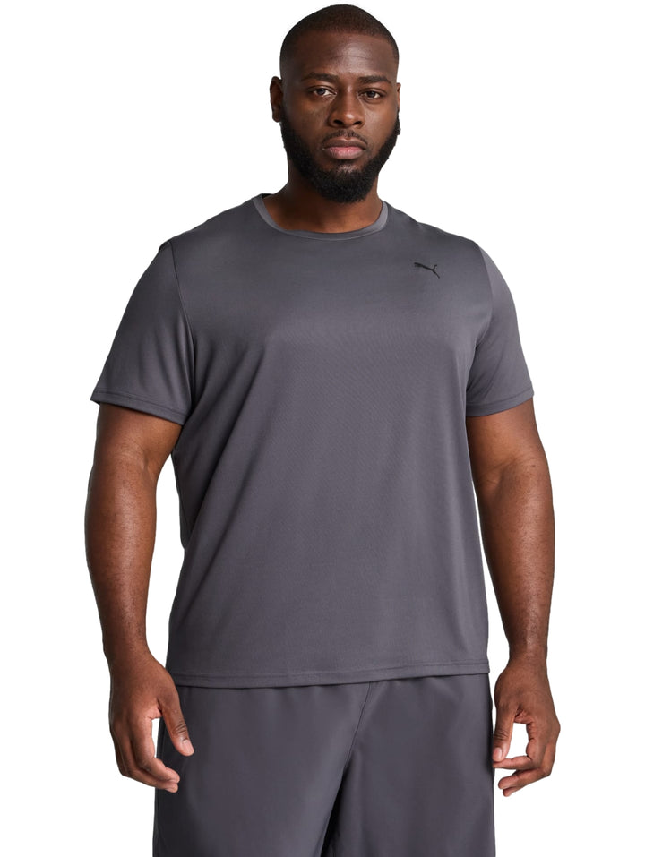 Hombre vistiendo una camiseta deportiva de color gris oscuro de la marca PUMA con cuello redondo y manga corta.